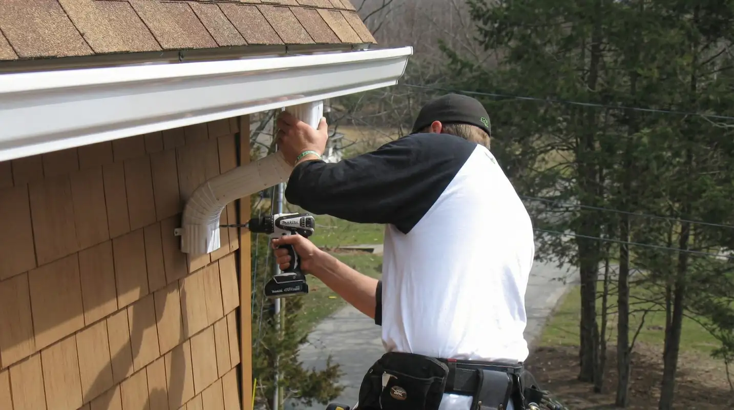 Professional contractor installing tan vinyl siding panels on a residential home exterior in Wichita, KS